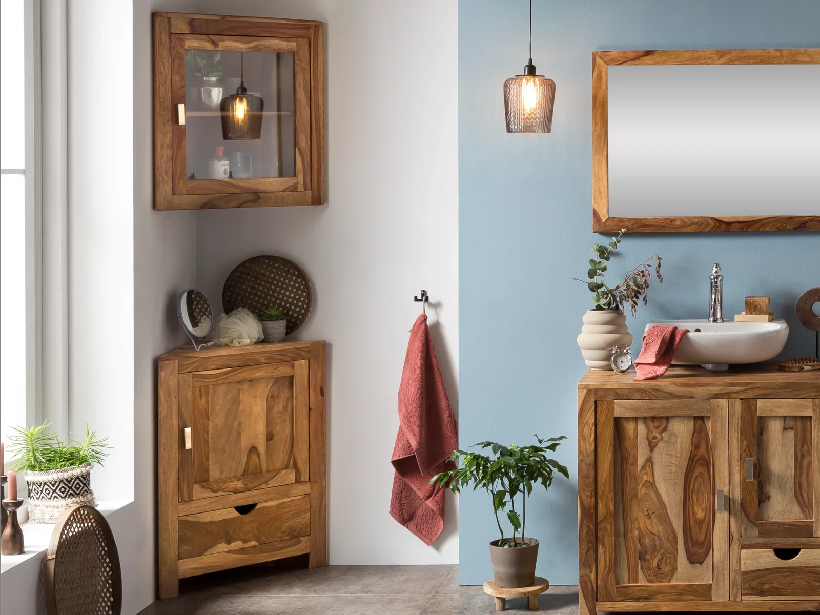 Modernes Badezimmer mit Waschtisch, Hängeschrank und Spiegel aus Massivholz, blaue Wand, warme Wohnatmosphäre