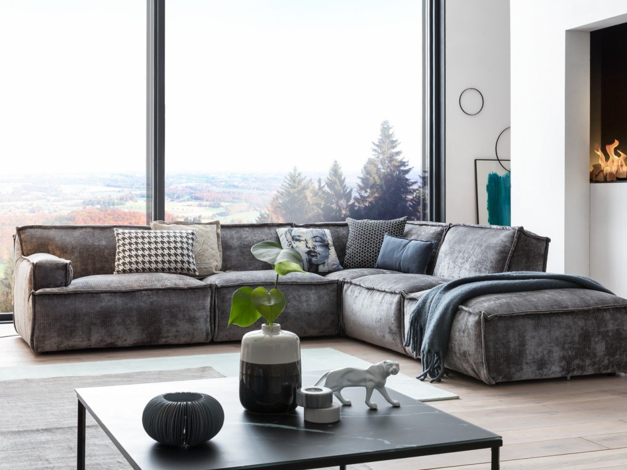 Moderne Stoffsofas in neutralen Tönen in hellem Wohnambiente, mit Kissen und Holzbeinen im skandinavischen, gemütlichen Stil.