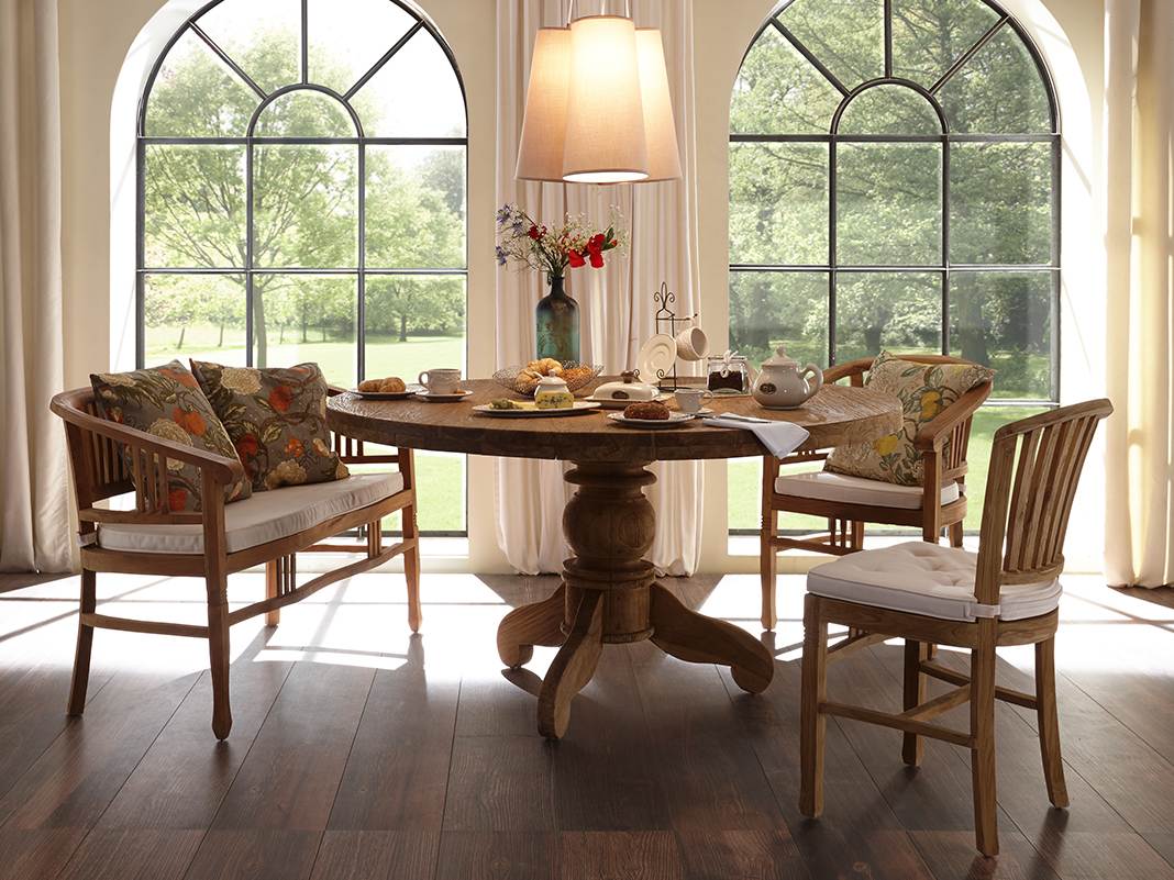 Runder Landhaustisch mit Stühlen in gemütlichem, rustikalem Esszimmer-Ambiente