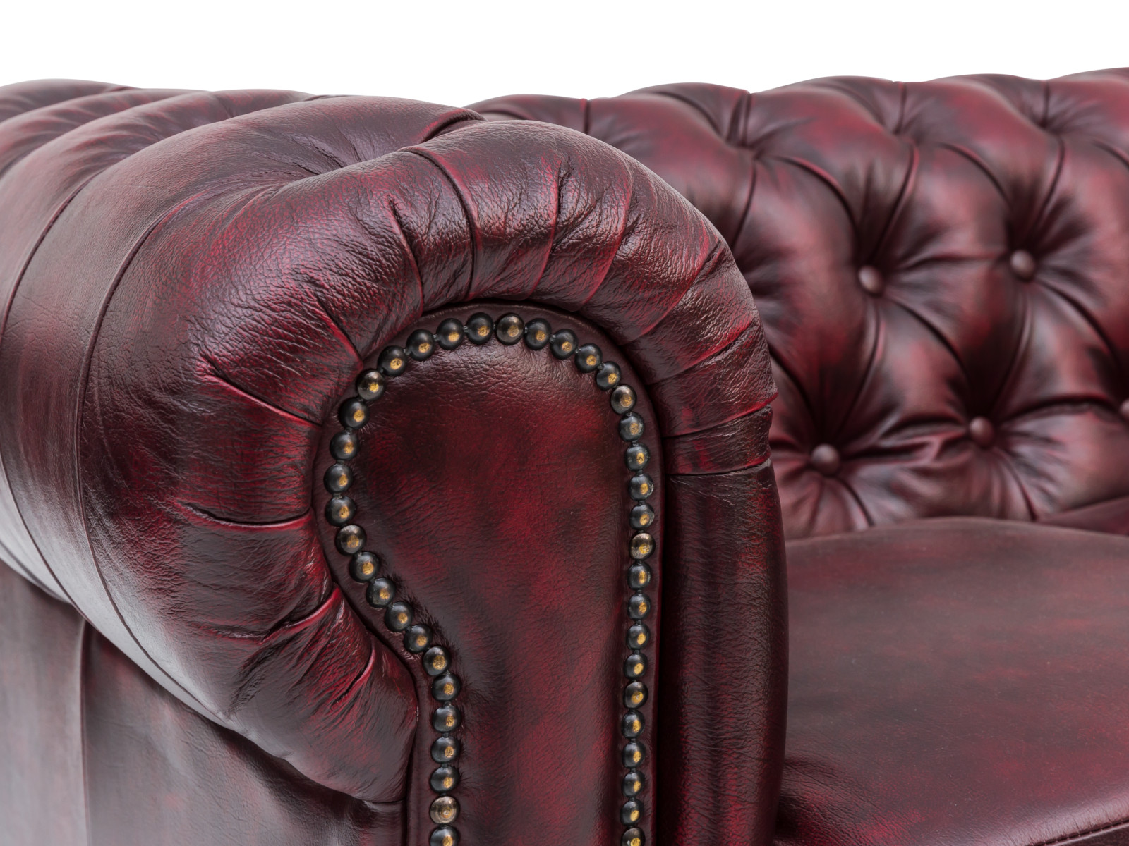45°-Detailansicht: Rote Chesterfield 6-Sitzer Echtleder-Sofa Armlehne mit Ziernieten. Freisteller zur Produktpräsentation.