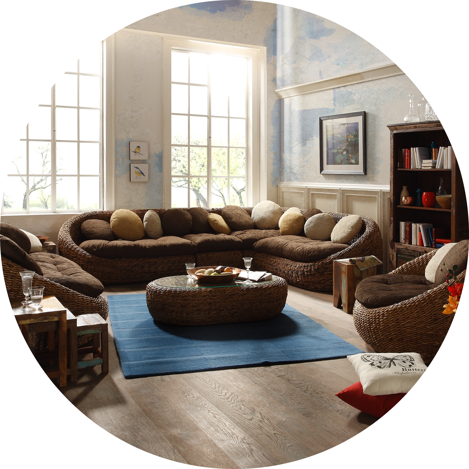 Safari-Wohnstil: gemütliches Wohnzimmer mit Rattanmöbeln, Lederakzenten, großen Grünpflanzen und warmen Naturtönen