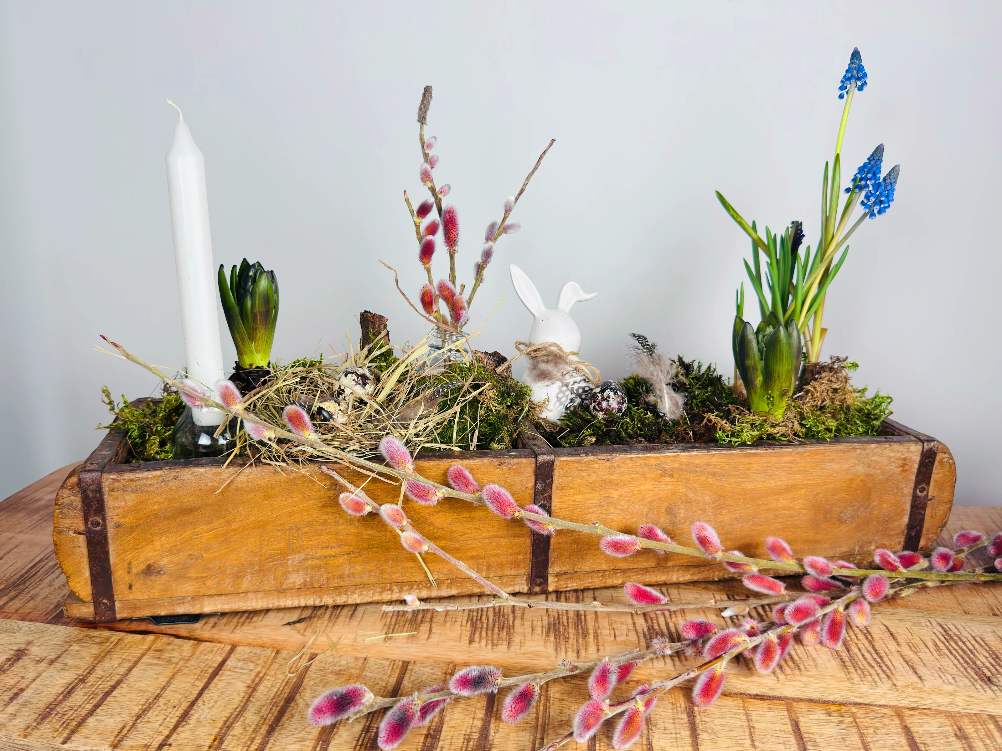 Ziegelform aus Holz in Frühlings-Ambiente: rustikale Holzform auf Tisch, warme natürliche Farbtöne zur Produktpräsentation