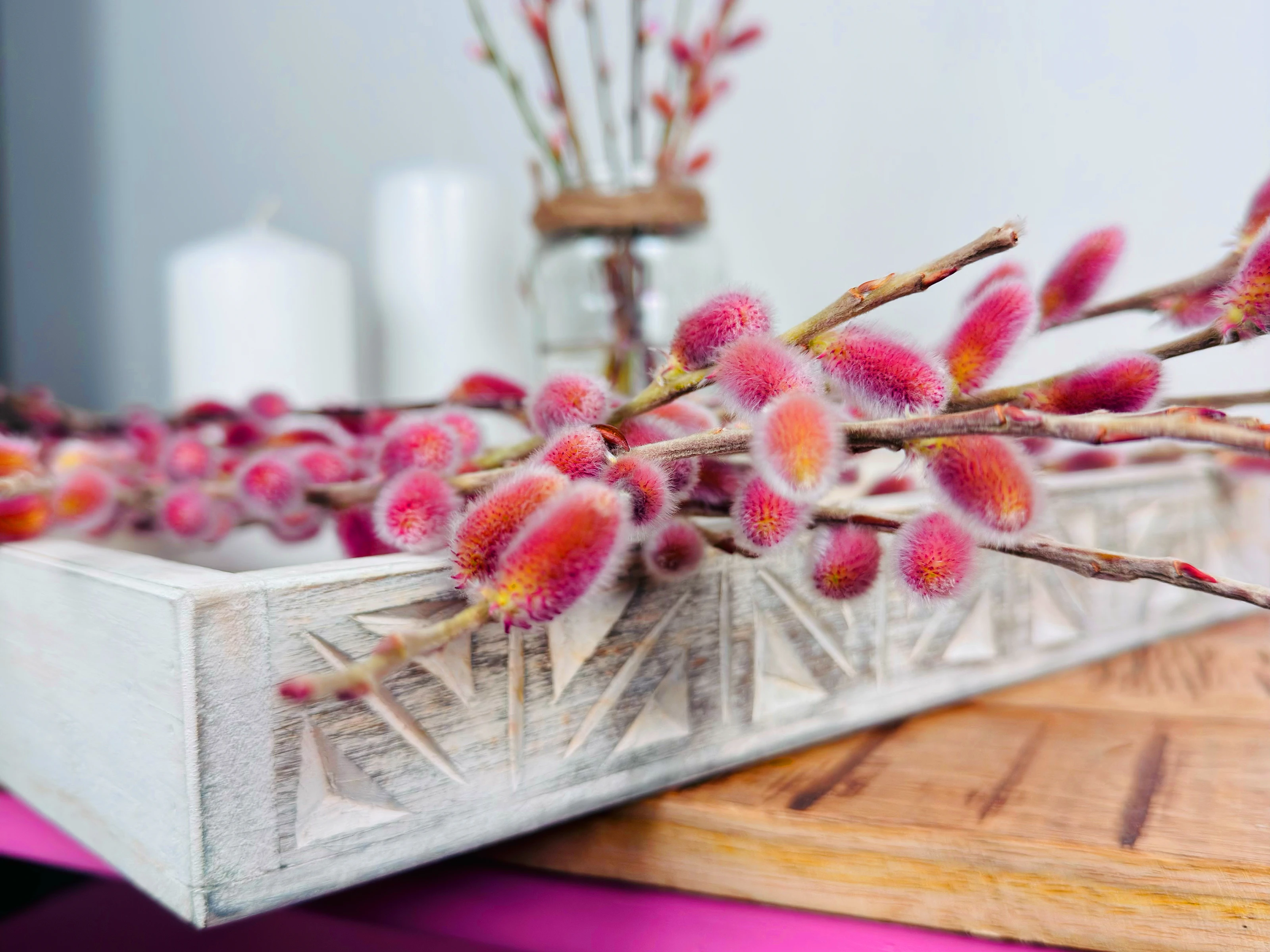 Osterdeko mit bunten, bemalten Eiern und Frühlingsblumen auf rustikalem Holztisch