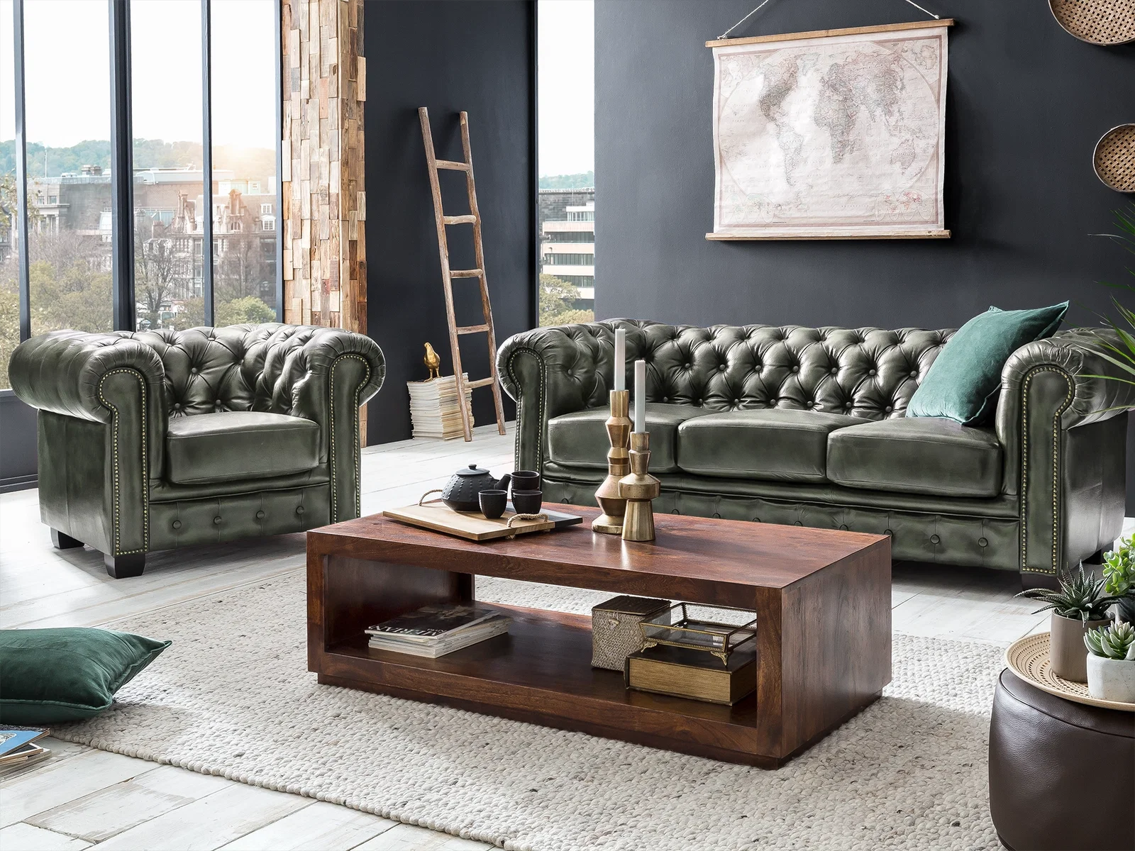 Grünes Chesterfield Sofa als 3-Sitzer aus Echtleder mit Knopfheftung neben einem passenden Sessel im Wohnzimmer