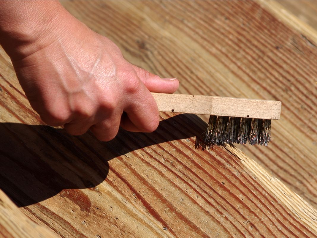 Nahaufnahme handgebürsteter Holzmaserung auf Holzoberfläche, warme natürliche Töne und sichtbare Struktur