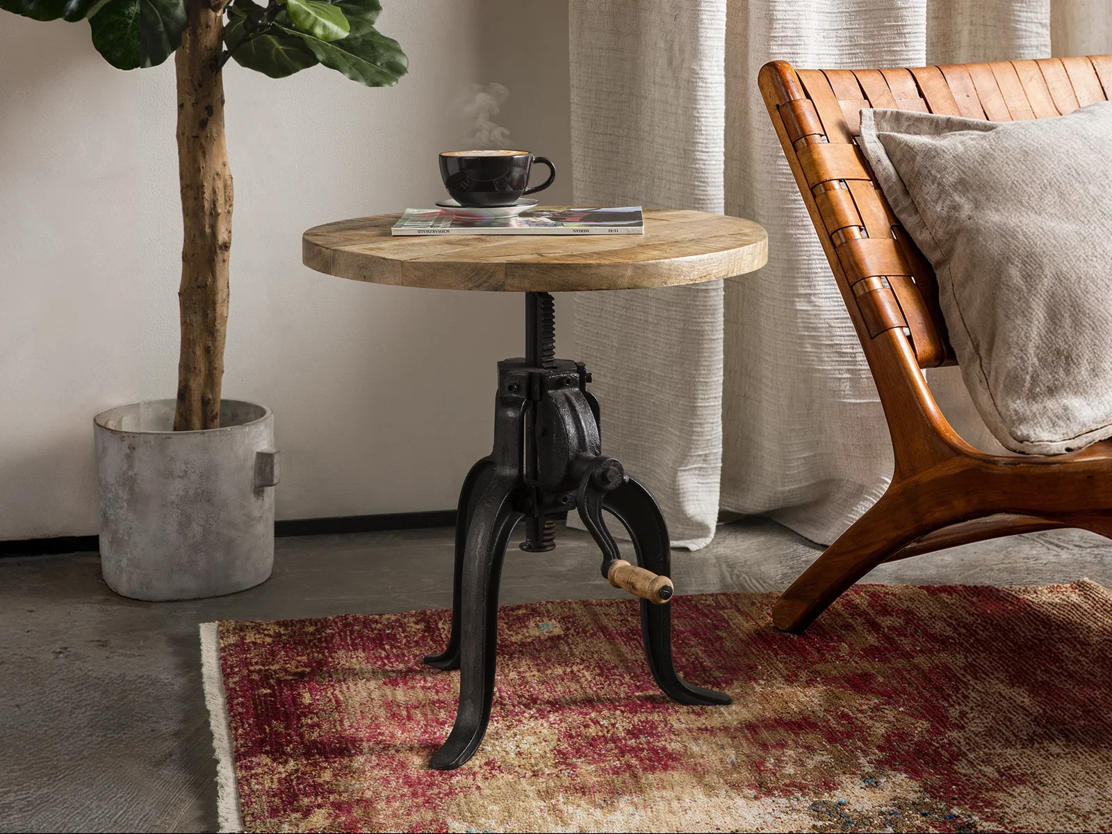 Runder Couchtisch Wasel mit Holzplatte und schwarzem Metallgestell in einem warm eingerichteten Wohnbereich im Chalet-Stil