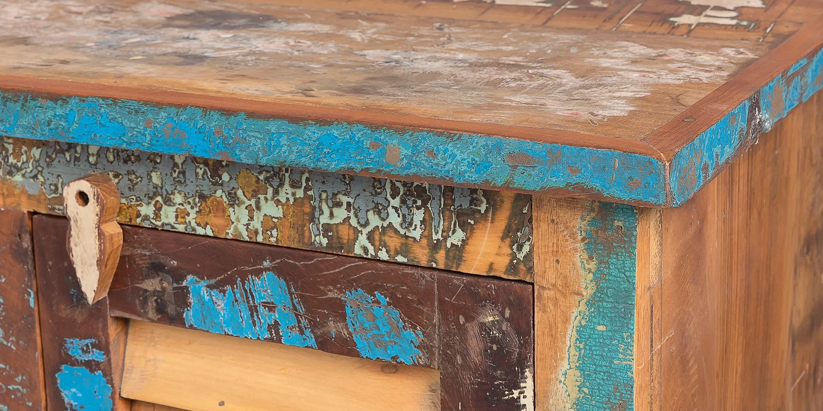 Detailaufnahme eines Möbelstücks der Serie Wakefield aus recyceltem Altholz mit farbigen Patinaspuren und markanter Holzstruktur