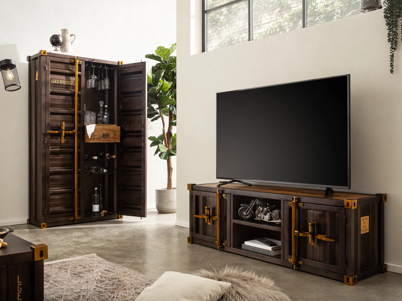 Schwarzes TV-Lowboard aus Massivholz und Metall im Loft-Look, kombiniert mit einem hohen Schrank und weichen Textilien für mehr Wohnlichkeit.