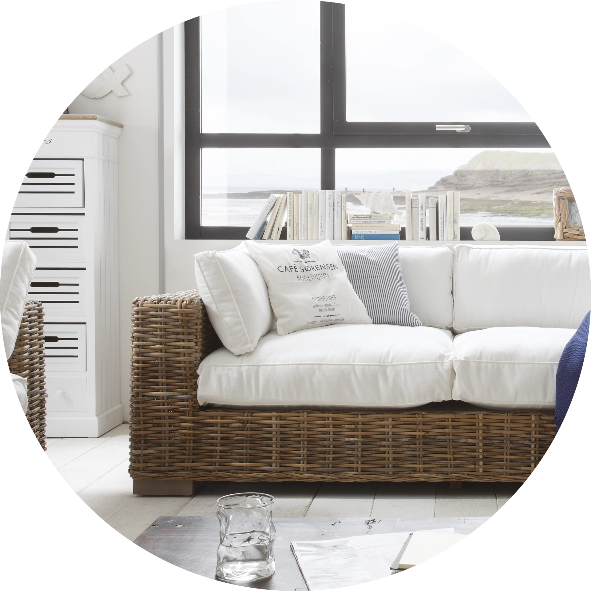 Maritimes Wohnambiente mit hellen Holzakzenten, blau-weißen Textilien und nautischer Deko (Anker, Tau) für gemütliche Strand-Atmosphäre