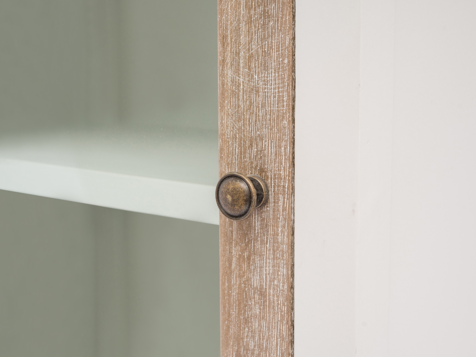 Detailbild Bad Hängeschrank Kansas: Nahaufnahme lackierte Paulownia-/MDF-Tür in Weiß mit rundem Metallknopf, Frontansicht.