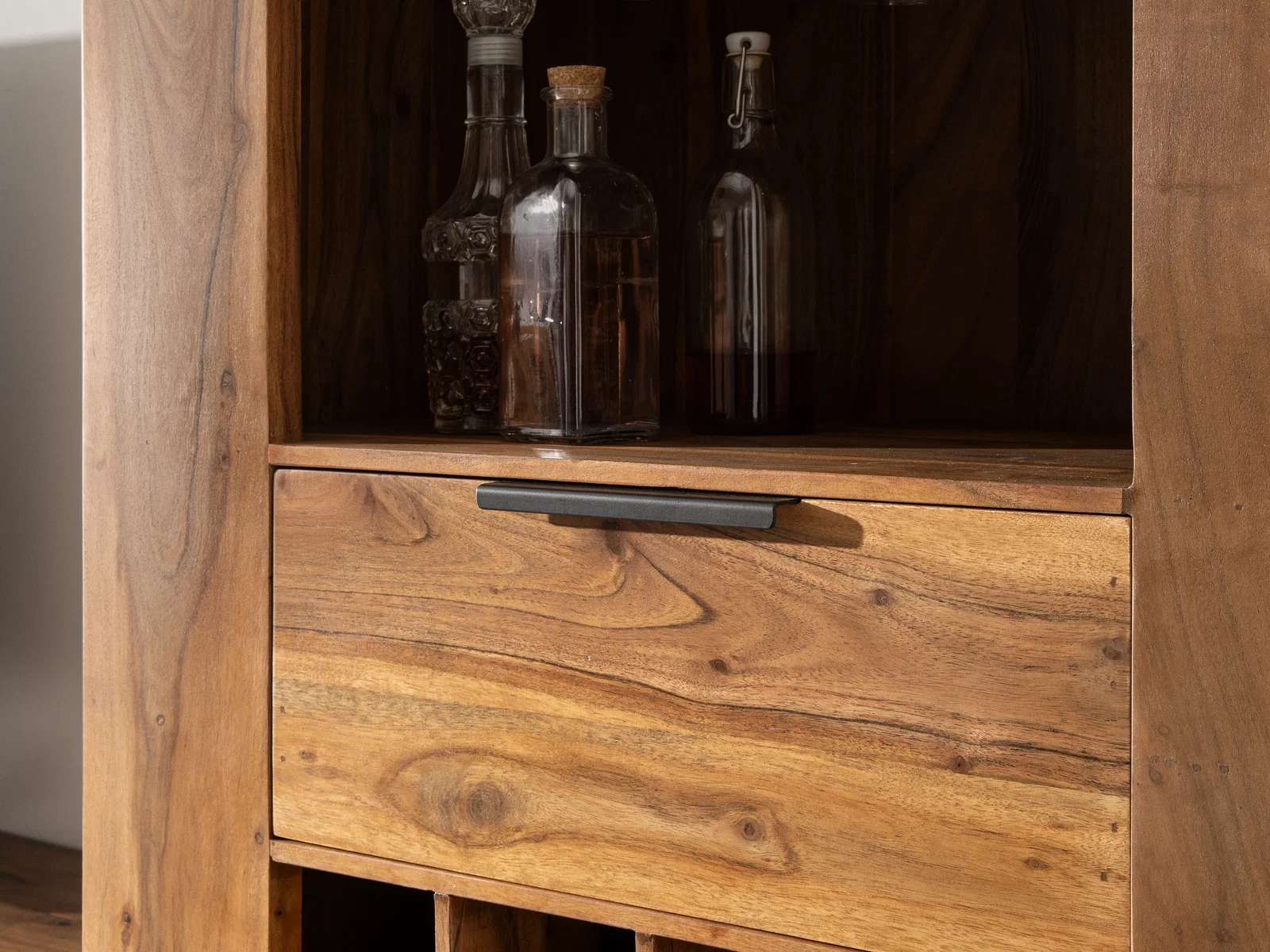 Detailansicht lackiertes Akazienholz-Highboard Osbon: Front der Schublade mit schwarzem Griff und prägnanter Holzmaserung.