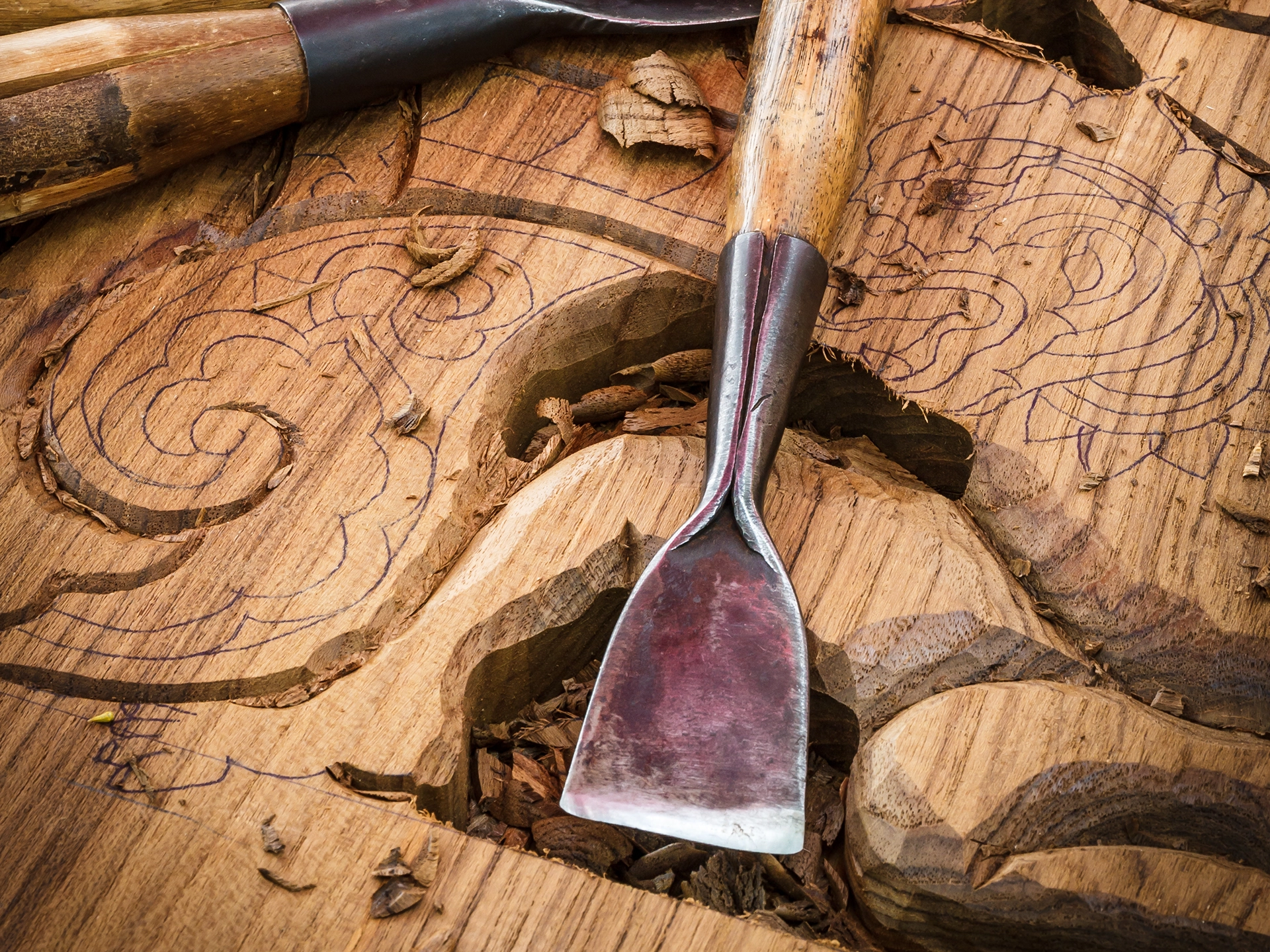Rustikales Ambiente mit Holzwerkzeug: Handwerkzeuge und Holzgriff auf Holzuntergrund, warme Naturtöne, Werkstattstimmung