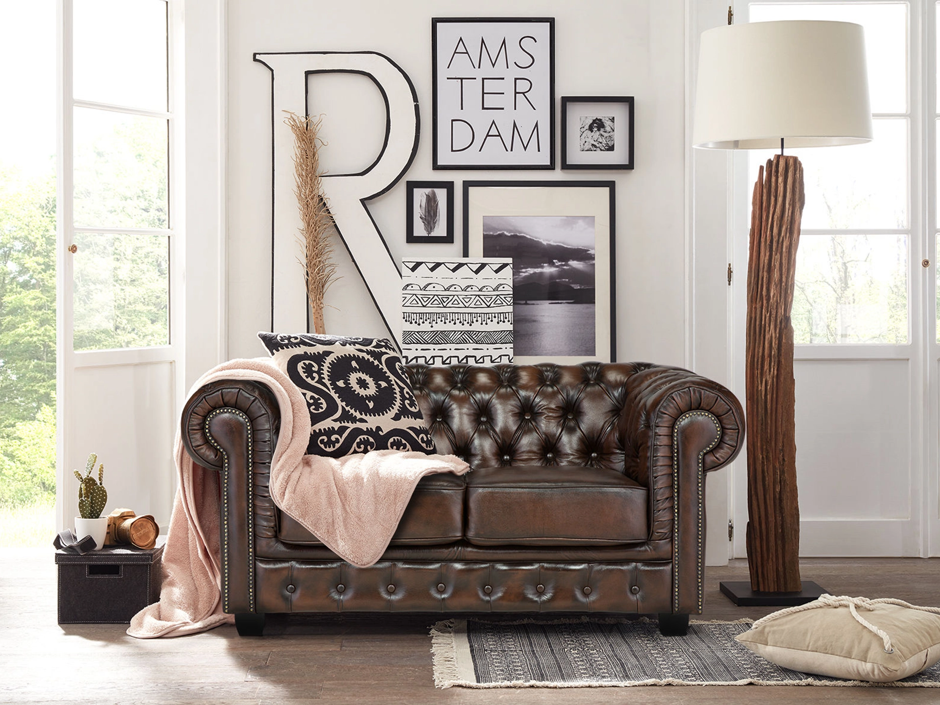 Braunes Chesterfield-Ledersofa mit tief gesteppter Knopfheftung und gewölbten Armlehnen in elegantem Vintage-Ambiente