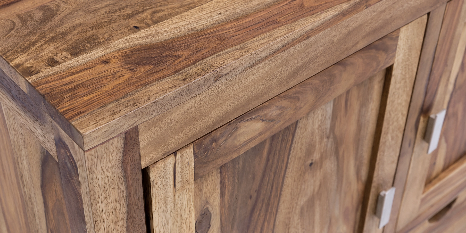 Detailaufnahme der warmen Holzmaserung und Kante des "Laros" Massivholzprodukts, lackierte Oberfläche, natürliche Farbtöne und feine Struktur