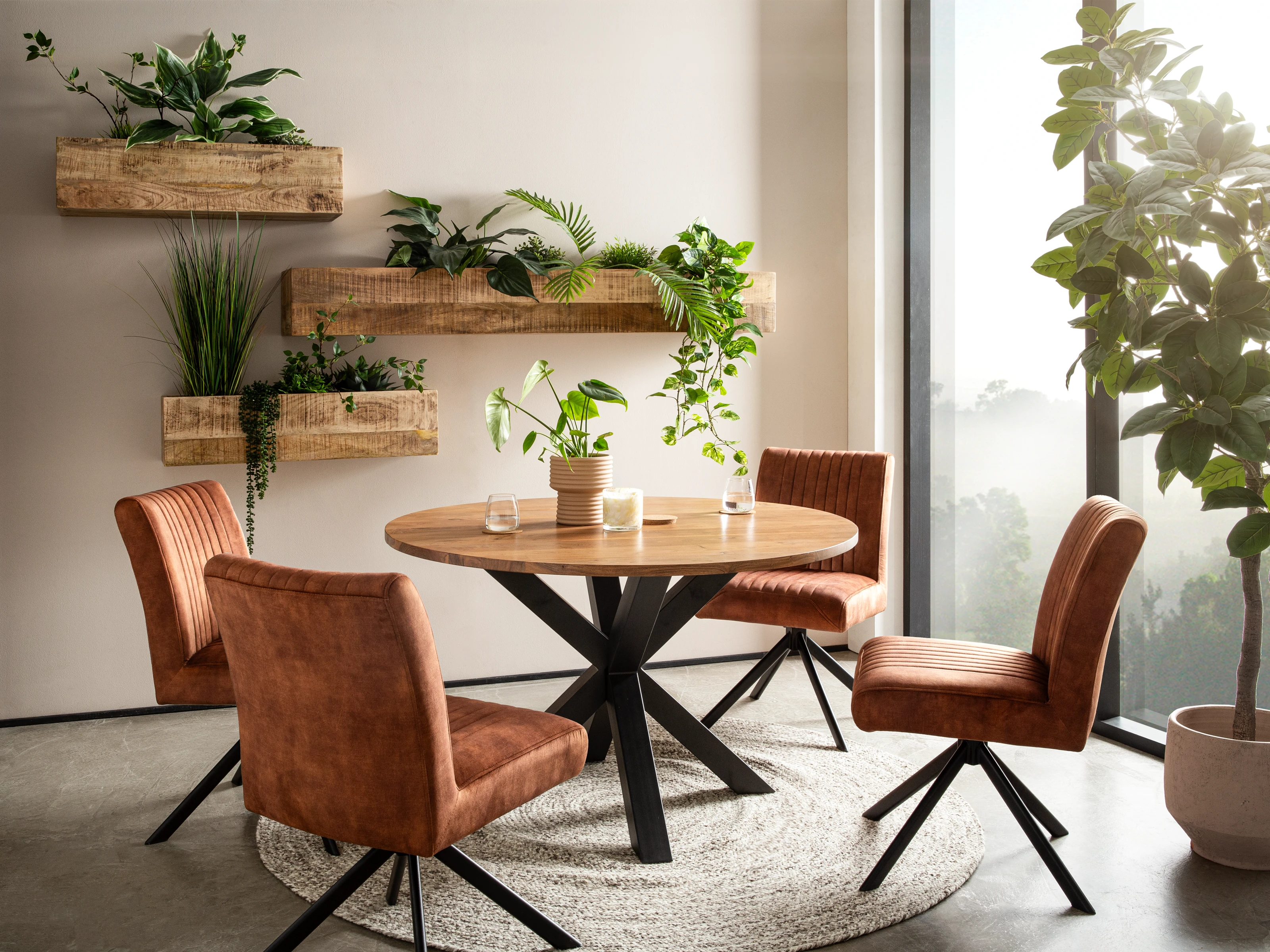 45°-Ansicht Wohnbeispiel: runder Mango-Holz-Esstisch mit schwarzem Metallgestell, 4 rostfarbene Drehstühle, Wandblumenkästen.