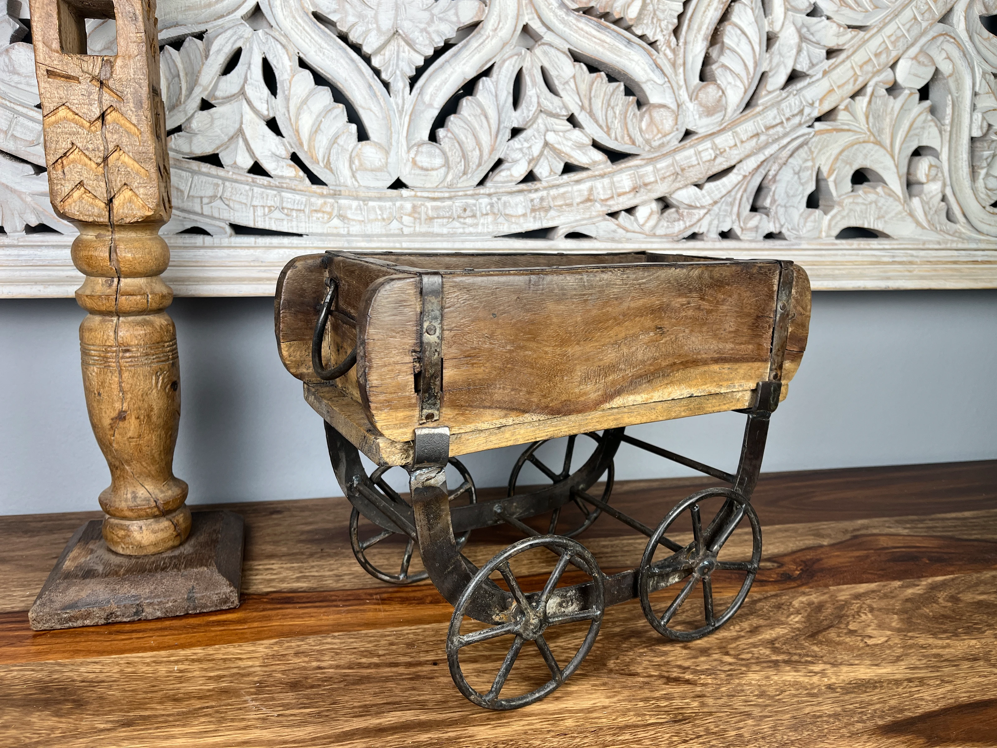 Modernes Wohnzimmer-Ambiente mit schmaler Holzkommode auf schwarzen Beinen, dekoriert mit Kerzen, Pflanzen und Bildern, in hellen Naturtönen und gemütlicher Stimmung