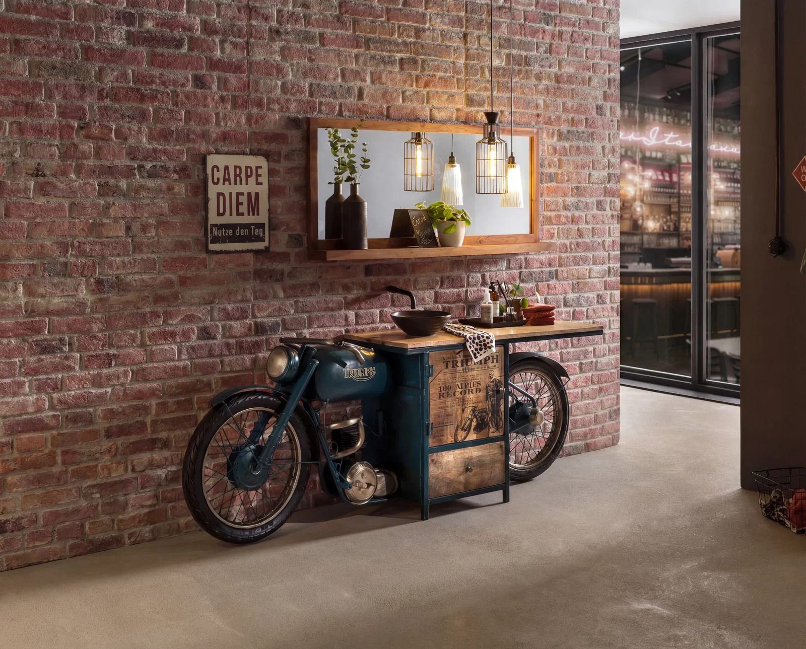 Vintage Motorrad-Waschtisch im Industrial-Stil vor Backsteinwand, mit Spiegel, Aufsatzbecken und warmem Loft-Ambiente, Schild „Carpe Diem“