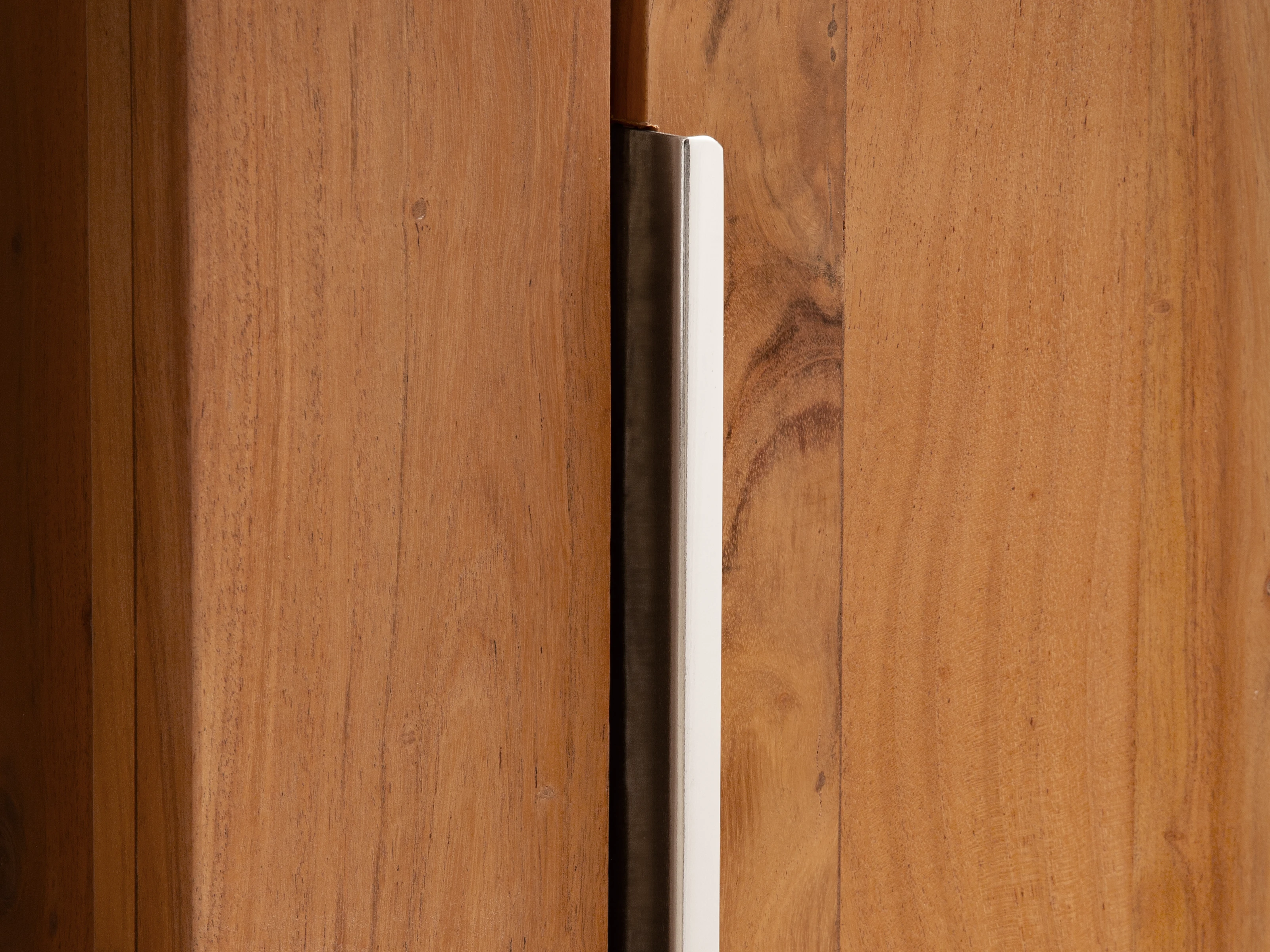 Detailaufnahme des Hochschranks Osbon aus Akazienholz mit silbernem Metallgriff, braune lackierte Holzoberfläche, Freisteller in Frontansicht geschlossen?