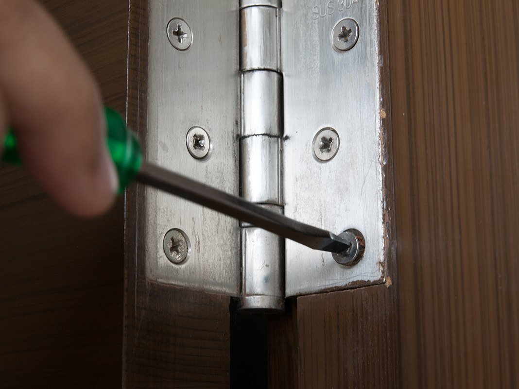 Nahaufnahme: Hand schleift Holzmöbel mit Schleifpapier – Schritt aus einem Ratgeber zum Aufarbeiten und Einstellen von Holzoberflächen.