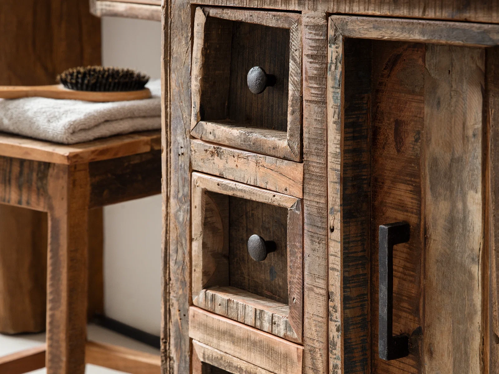 Detailansicht des Waschbeckenunterschranks Sumatra aus Altholz mit sichtbarer Holzstruktur und dunklen Metallgriffen als rustikales Holzmöbel im Chalet-Stil