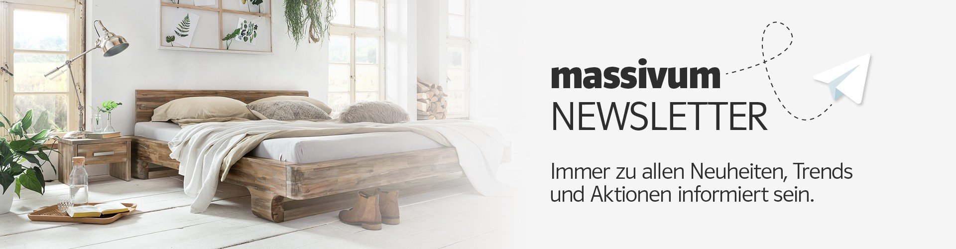 Moderner massiver Holz-Schreibtisch vor heller Wand, minimalistisches Home-Office-Setup mit Laptop, Lampe und Pflanzen