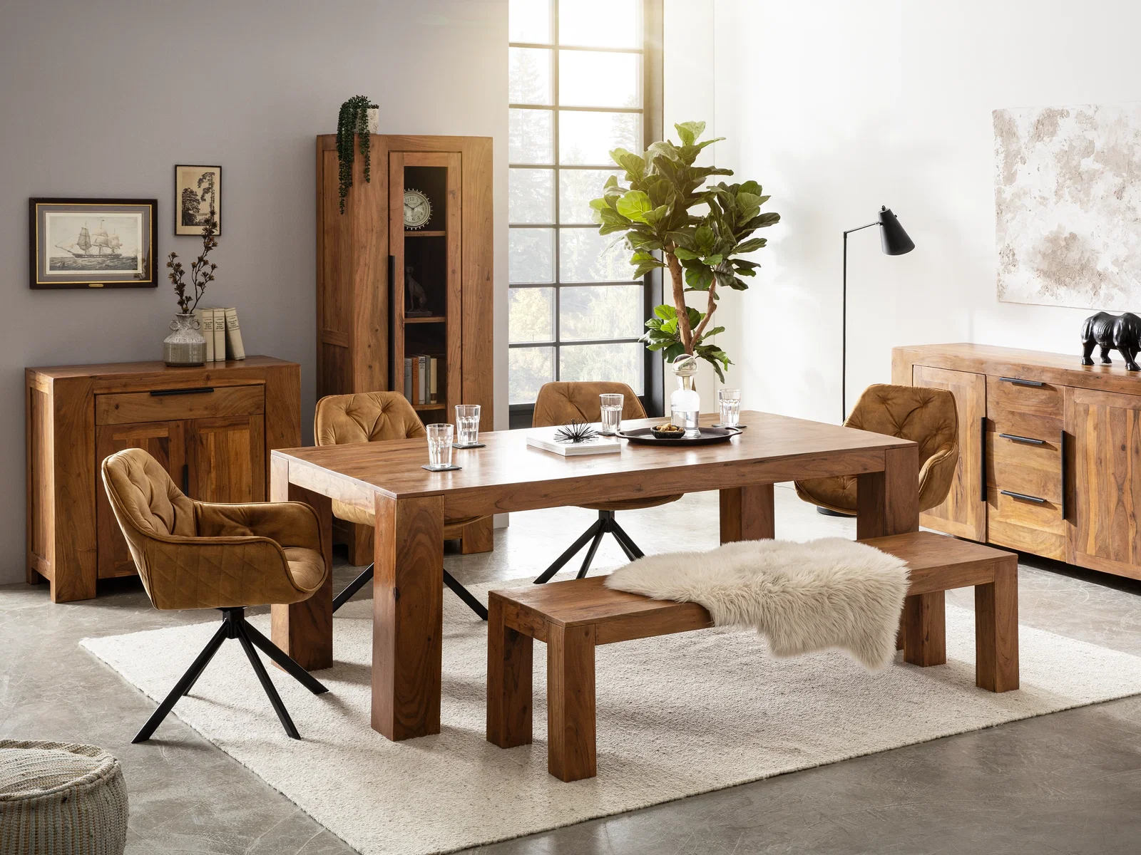 Modernes Esszimmer mit massivem Holztisch, Bank, Vitrine und Sideboards in warmem Naturholz, kombiniert mit braunen Polsterstühlen.